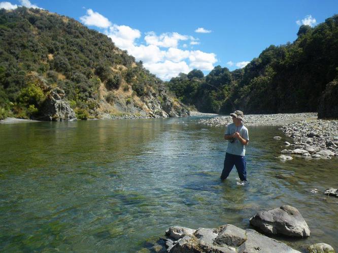Angler fly fishing a scenic South Island river