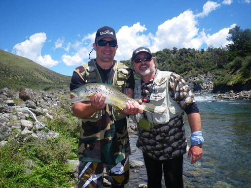 Two anglers holding trout while fly fishing in New Zealand