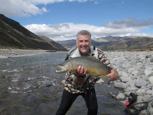 Image of a Deano catching a rainbow trout while fly fishing in NZ